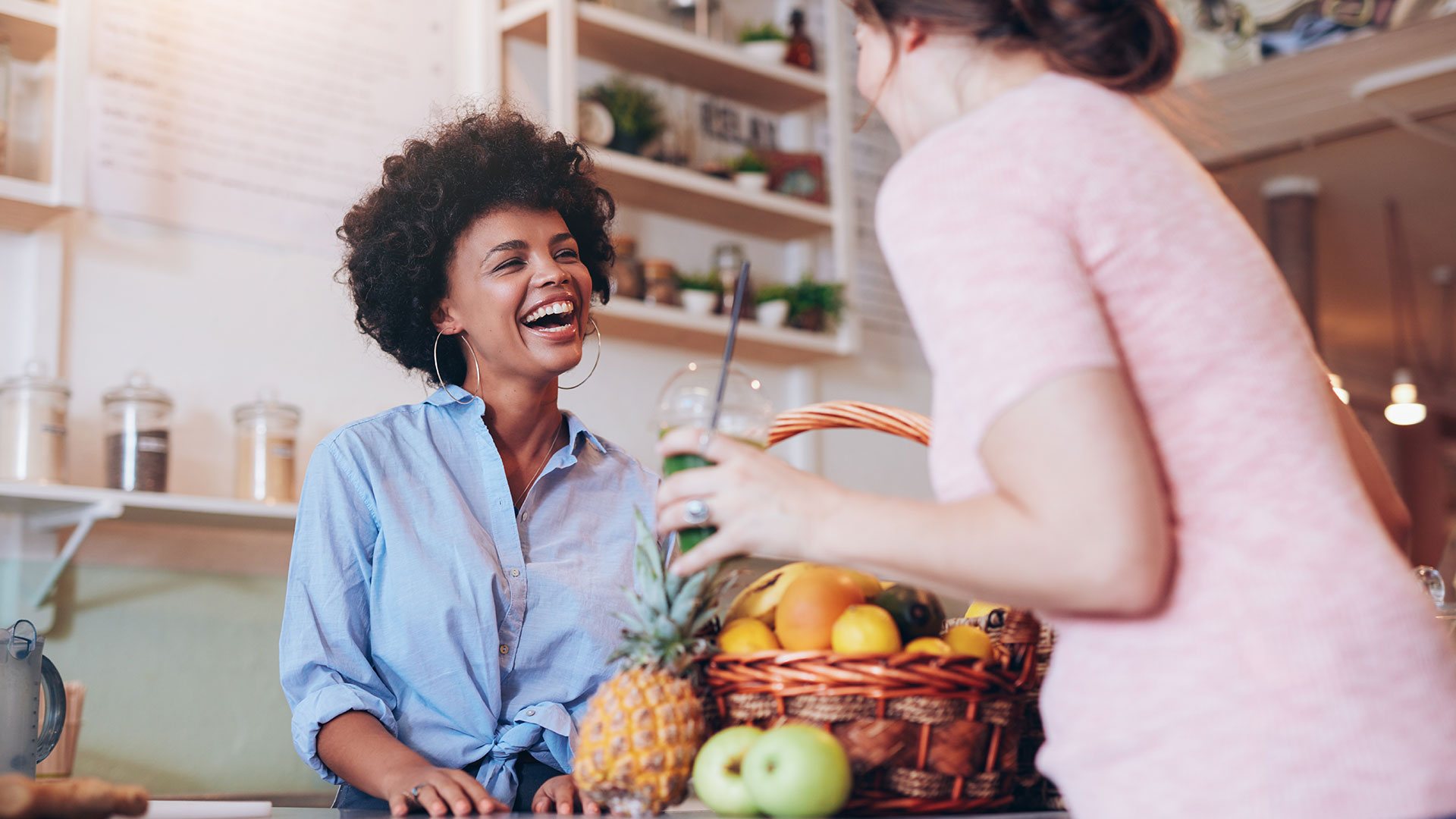 Female Shop owner smiling with client at checkout counter